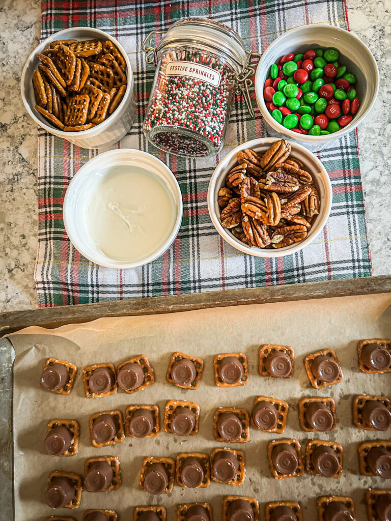 Ingredients to make fun and festive rolo pretzel bits. Nonpareils sprinkles, white chocolate, m&m's, pecans, snap pretzels, rolos