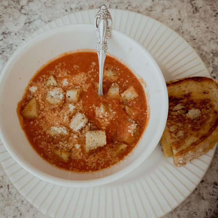 Creamy homemade tomato soup using canned crushed tomatoes. Topped with croutons and parmesan served with grilled cheese.