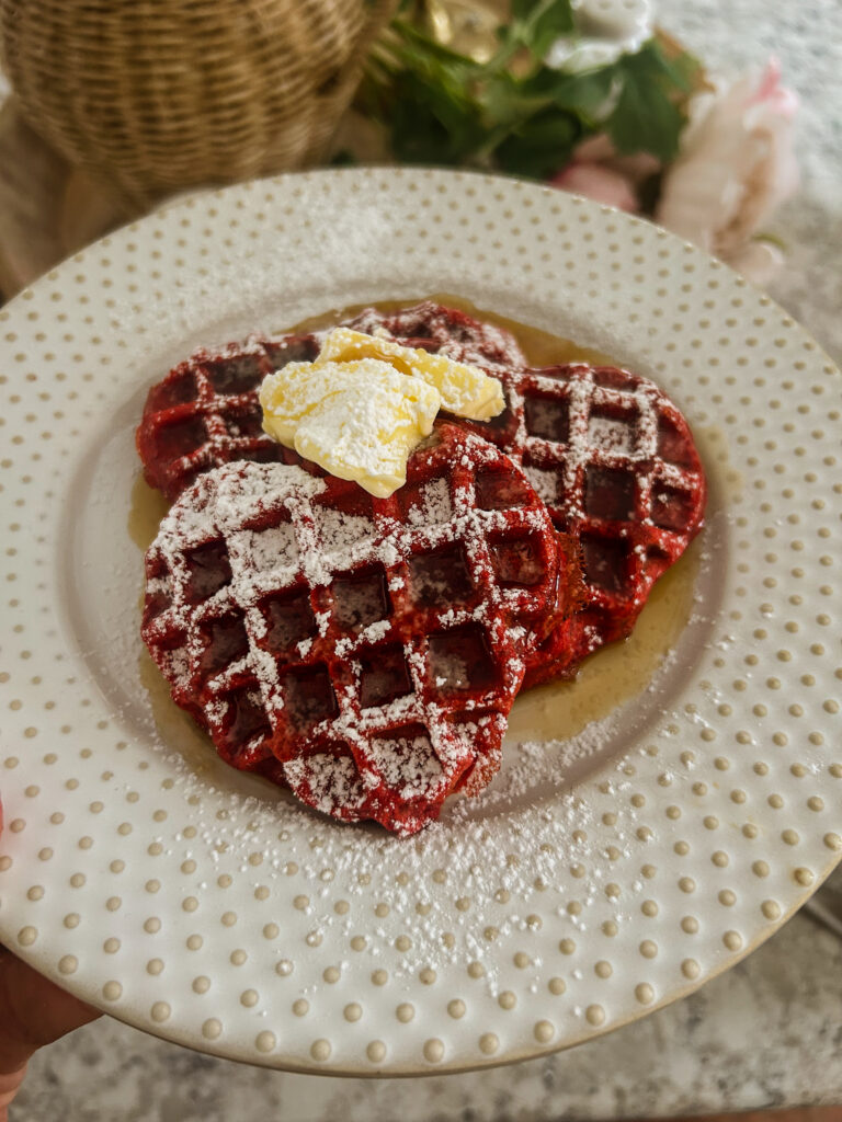 red velvet waffles with butter maple syrup and powdered sugar